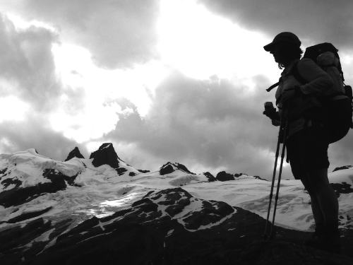 Silhouetted figure in front of glaciated mountains