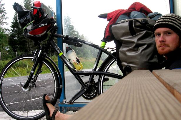 Cyclist seeking refuge in a bus shelter