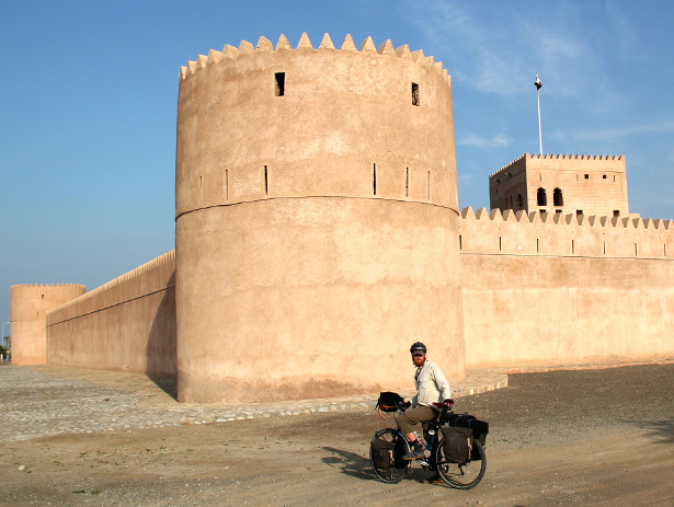 Cycling past an Omani desert fort