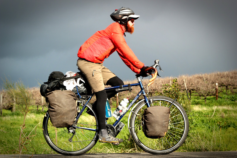 Cycling through vineyards beneath a stormy sky